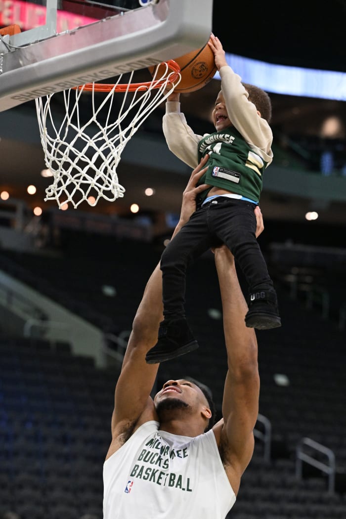 Milwaukee Bucks forward Giannis Antetokounmpo (34) lifts his middle son Maverick up to dunk